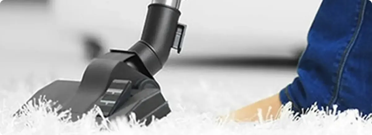 Close-up of a professional vacuuming a white carpet in Bountiful.